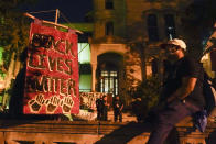 Protesters spend time in a church lot, Friday, Sept. 25, 2020, in Louisville. Breonna Taylor's family demanded Friday that Kentucky authorities release all body camera footage, police files and the transcripts of the grand jury hearings that led to no charges against police officers who killed the Black woman during a March drug raid at her apartment. (AP Photo/Darron Cummings)