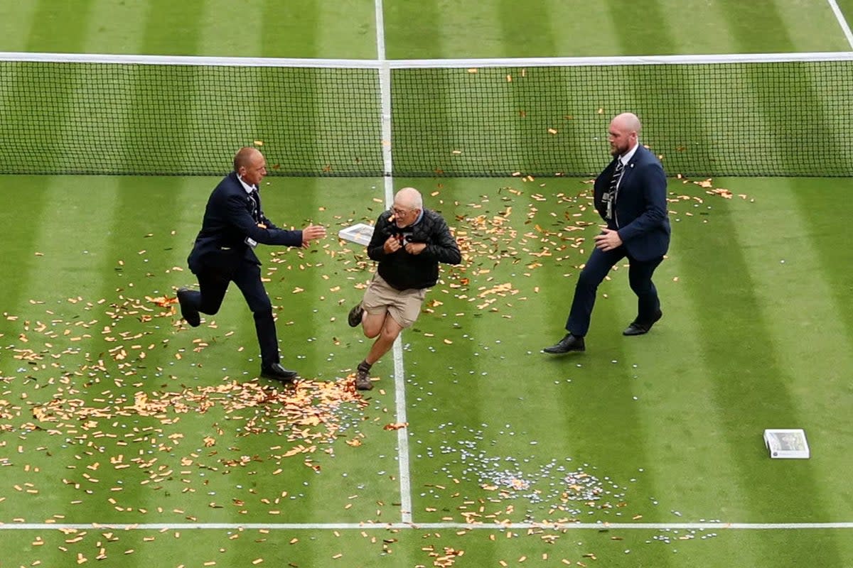 A protester is challenged by security on court 18 after a Just Stop Oil protest using orange confetti and a jigsaw puzzle (Getty Images)