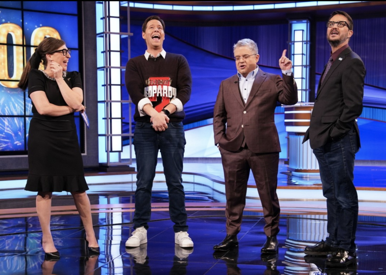 Ike Barinholtz holds his trophy while onstage with host Mayim Bialik and contestants Patton Oswalt and Wil Wheaton. (Photo: Sony Pictures Television via Instagram)