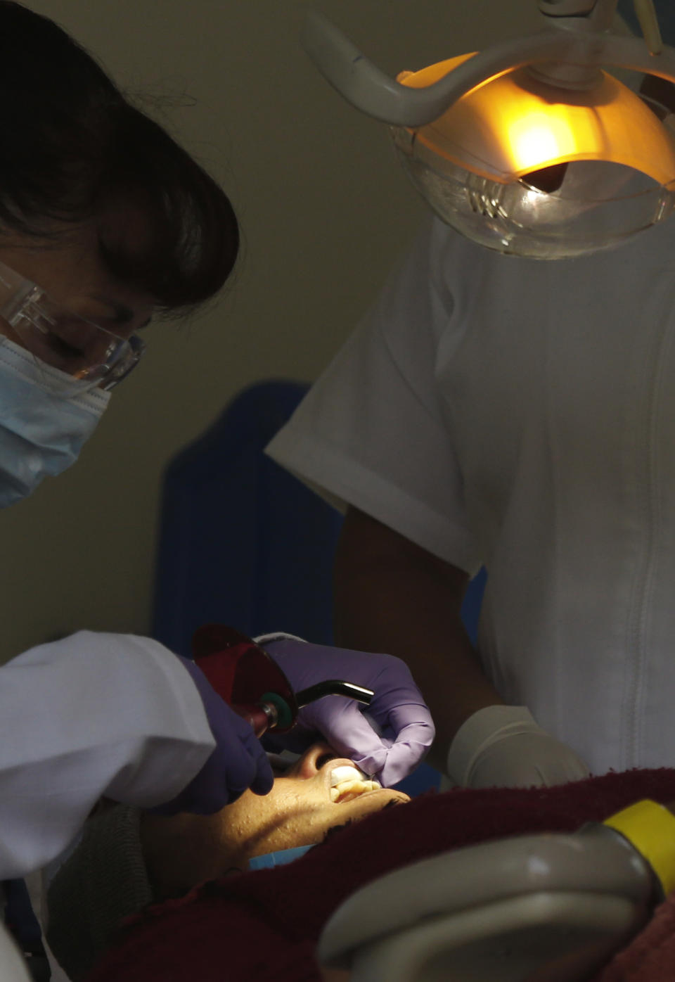 A Central American migrant receives a dental checkup in a shelter at the Jesus Martinez stadium in Mexico City, Tuesday, Nov. 6, 2018. Humanitarian aid converged around the stadium in Mexico City where thousands of Central American migrants winding their way toward the United States were resting Tuesday after an arduous trek that has taken them through three countries in three weeks. (AP Photo/Marco Ugarte)