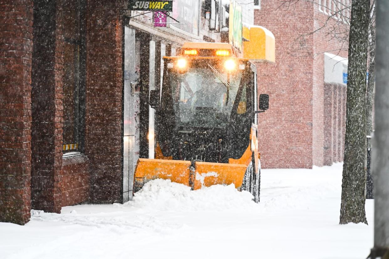 A plow clears a Moncton sidewalk after the snowiest part of the storm in that city. (Patrick Lacelle/Radio-Canada - image credit)