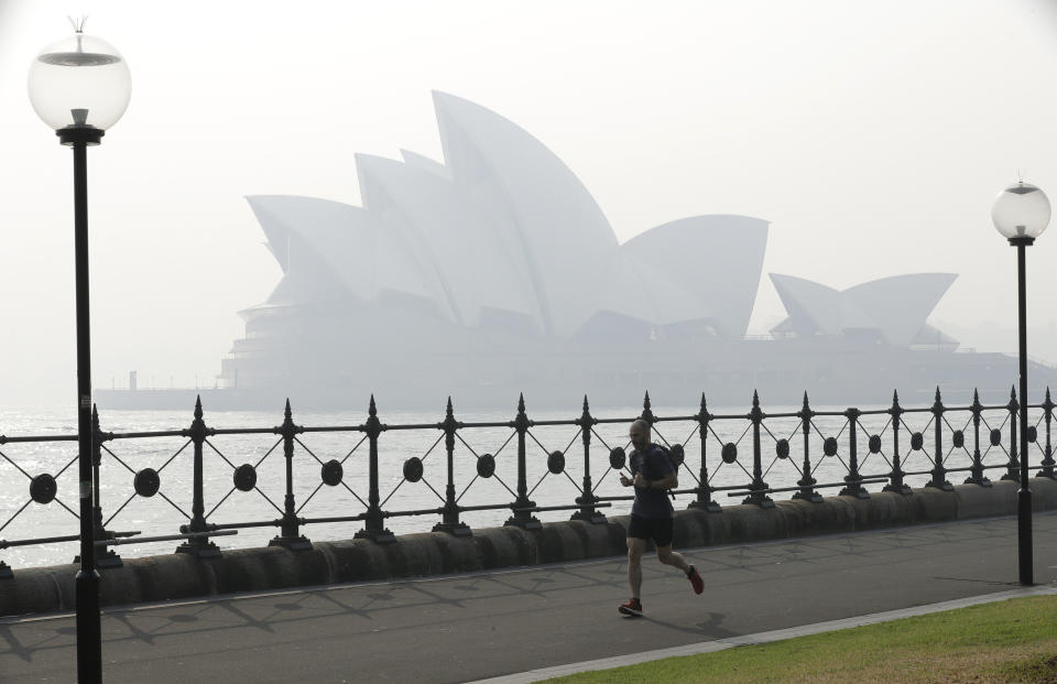 A jogger runs in the morning as smoke haze hangs over the Sydney Opera House in Sydney, on Nov. 21, 2019.&nbsp; (Photo: ASSOCIATED PRESS)