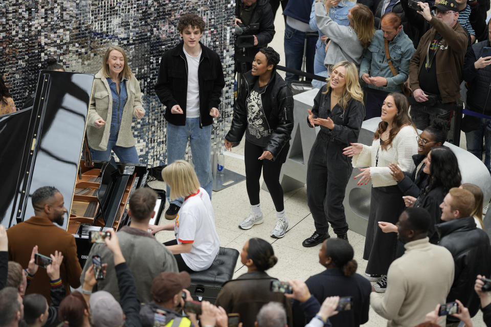 Members of the Mark de Lisser singers preform the iconic ABBA song 'Waterloo' at Waterloo Station in London, Saturday, April 6, 2024. Fans are celebrating 50 years since ABBA won its first big battle with “Waterloo.” A half century ago on Saturday, April 6, the Swedish quartet triumphed at the 1974 Eurovision Song Contest with the peppy love song. (AP Photo/Alastair Grant)