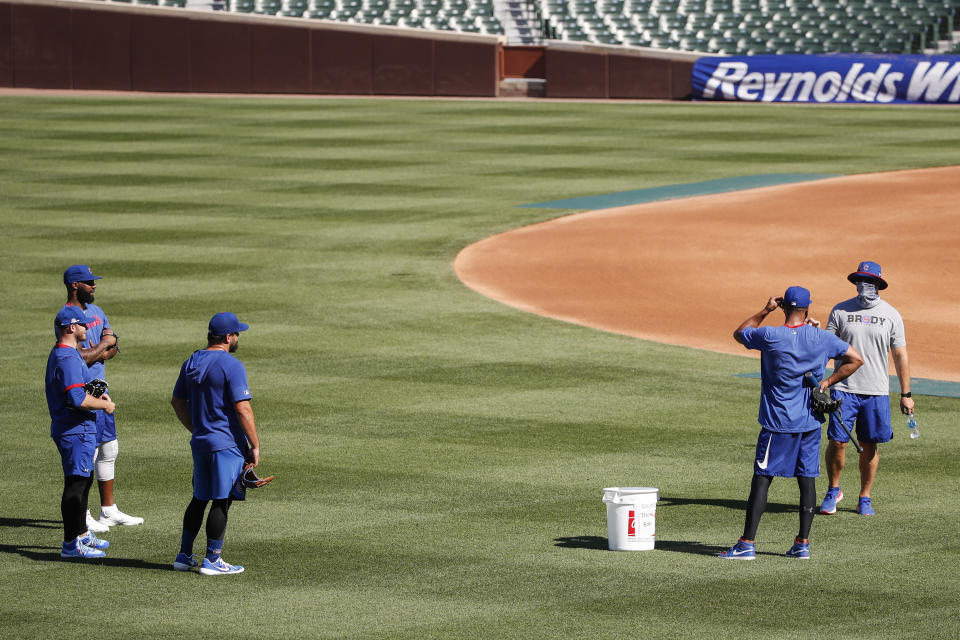 Chicago Cubs manager David Ross, right, talks to his players during baseball practice at Wrigley Field on Friday, July 3, 2020 in Chicago. (AP Photo/Kamil Krzaczynski)