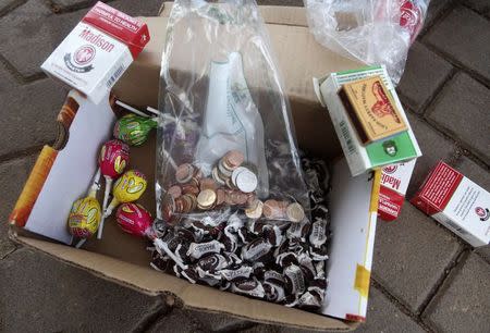 A bag of new Zimbabwean coins, candies and packs of cigarettes are seen in Harare, December 18, 2014. REUTERS/Philimon Bulawayo