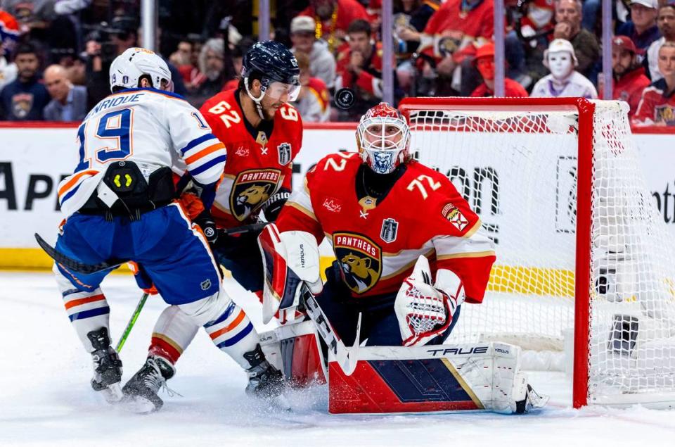 Florida Panthers goaltender Sergei Bobrovsky (72) keeps his eyes on a flying puck as Edmonton Oilers center Adam Henrique (19) and Florida Panthers defenseman Brandon Montour (62) battle it out in front of the Panthers net during second period action in game 7.