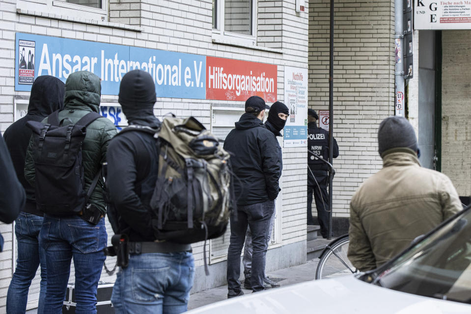 Police officers stay in front of a building of the Ansaar International association in Duesseldorf, Germany, Wednesday, May 5. 2021. The German government on Wednesday banned the Muslim organization. Buildings in 10 German states were raided, according to German news agency dpa, which said that the donations Ansaar collected were donated to welfare projects but also to groups such as Al-Nusra in Syria, the Palestinians' Hamas group and Al-Shabaab in Somalia. (Marcel Kusch/dpa via AP)