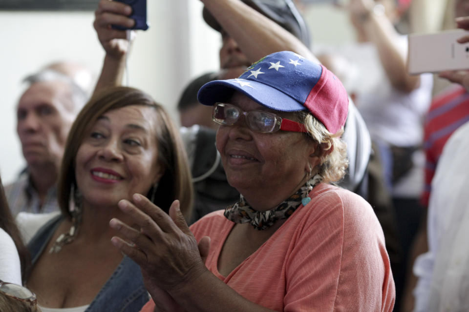 Supporters of Venezuela's self-proclaimed interim president Juan Guaido listen as he speaks during a meeting with electricity experts in Caracas, Venezuela, Thursday, March 28, 2019. The Venezuelan government on Thursday said it has barred Guaido from holding public office for 15 years, though the National Assembly leader responded soon afterward that he would continue his campaign to oust President Nicolas Maduro. (AP Photo/Boris Vergara)