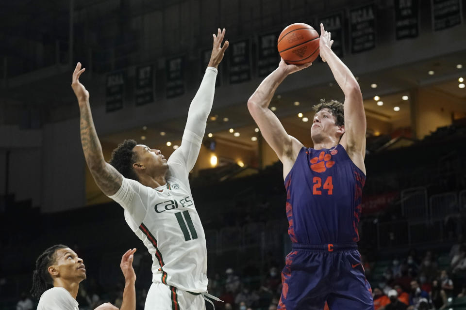 Clemson forward PJ Hall (24) aims a shot to the basket as Miami guard Jordan Miller (11) defends during the second half of an NCAA college basketball game, Saturday, Dec. 4, 2021, in Coral Gables, Fla. (AP Photo/Marta Lavandier)