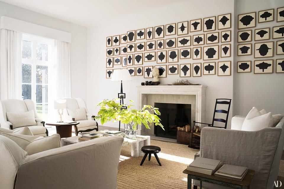 A set of 60 drawings by Allan Mccollum covers a wall in the living room. Shaker No. 7 rocking chair; ebonized tripod stool by Charlotte Perriand.