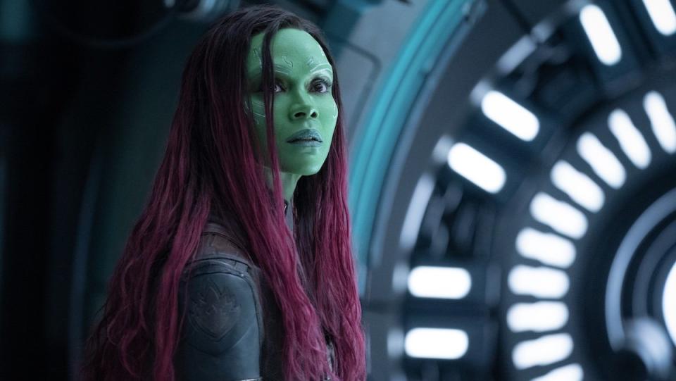 Gamora with green skin and red hair looks over her shoulder in Guardians of the Galaxy Vol. 3