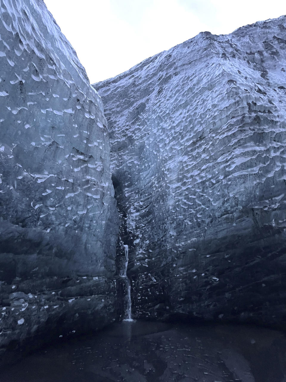 This Nov. 18, 2023 image provided by Beth Harpaz shows the icy blue walls of an ice cave at Vatnajokull National Park, located on an ice field in southeastern Iceland. The caves can only be explored on a tour with a registered guide. Winter crampons must be attached to shoes and boots for traction to avoid slipping. (Beth Harpaz via AP)