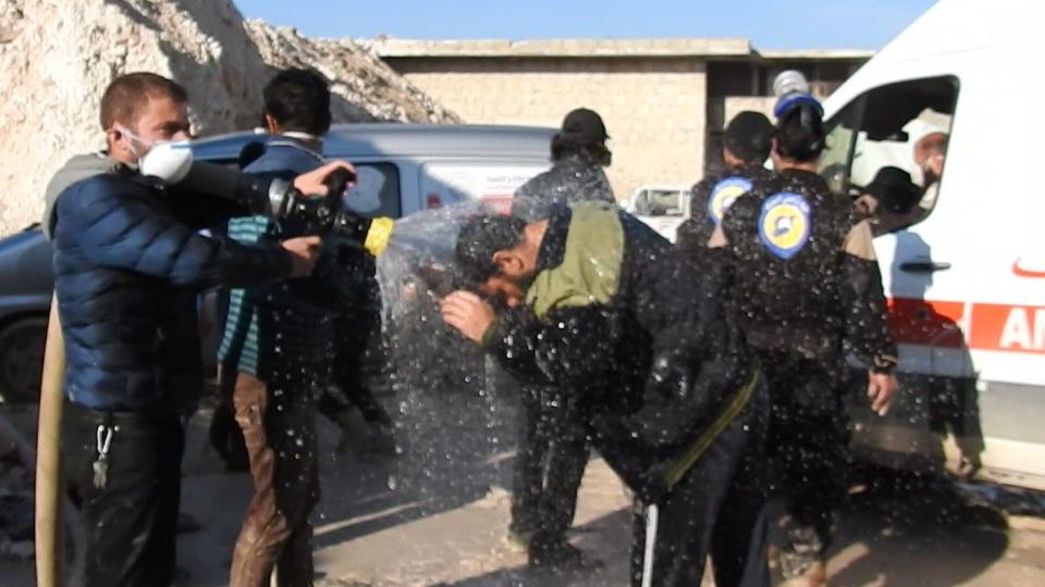 Civil defense members try to reduce the effects of chlorine gas with water as they carry out search and rescue efforts after a gas attack in Syria.