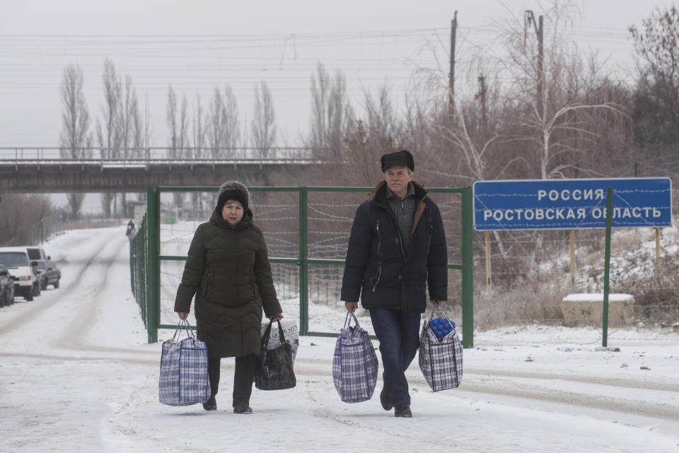 People walk crossing the border from Russia to Ukrainian side of the Ukraine - Russia border in Milove town, eastern Ukraine, Sunday, Dec. 2, 2018. On a map, Chertkovo and Milove are one village, crossed by Friendship of Peoples Street which got its name under the Soviet Union and on the streets in both places, people speak a mix of Russian and Ukrainian without turning choice of language into a political statement. (AP Photo/Evgeniy Maloletka)