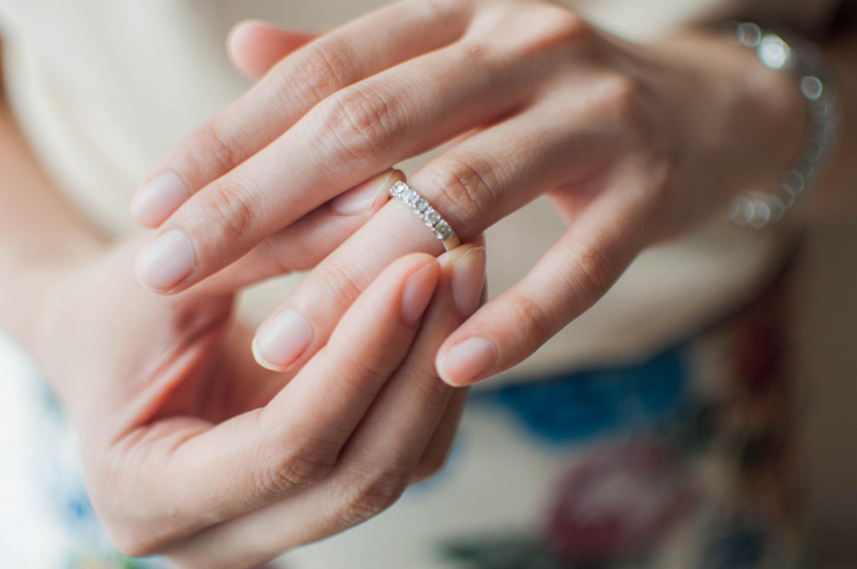 A close-up view of a young woman wearing a white gold wedding ring. [Photo: Getty]