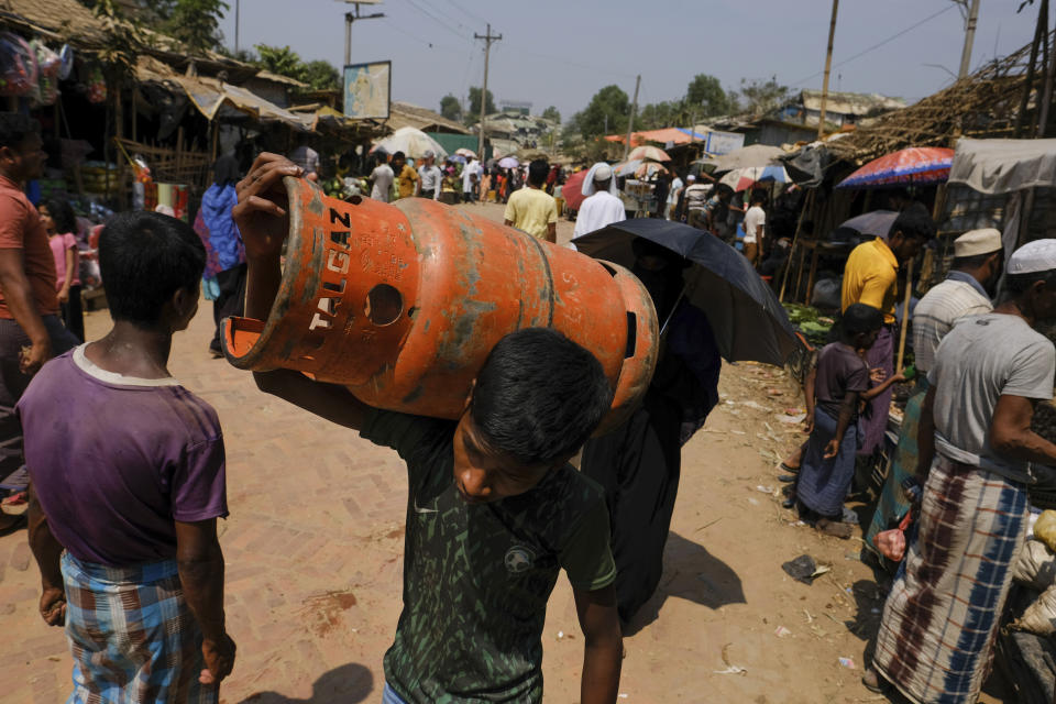 A Rohingya refugee carries a gas cylinder at a refugee camp in the Cox's Bazar district of Bangladesh, on March 9, 2023. (AP Photo/Mahmud Hossain Opu)