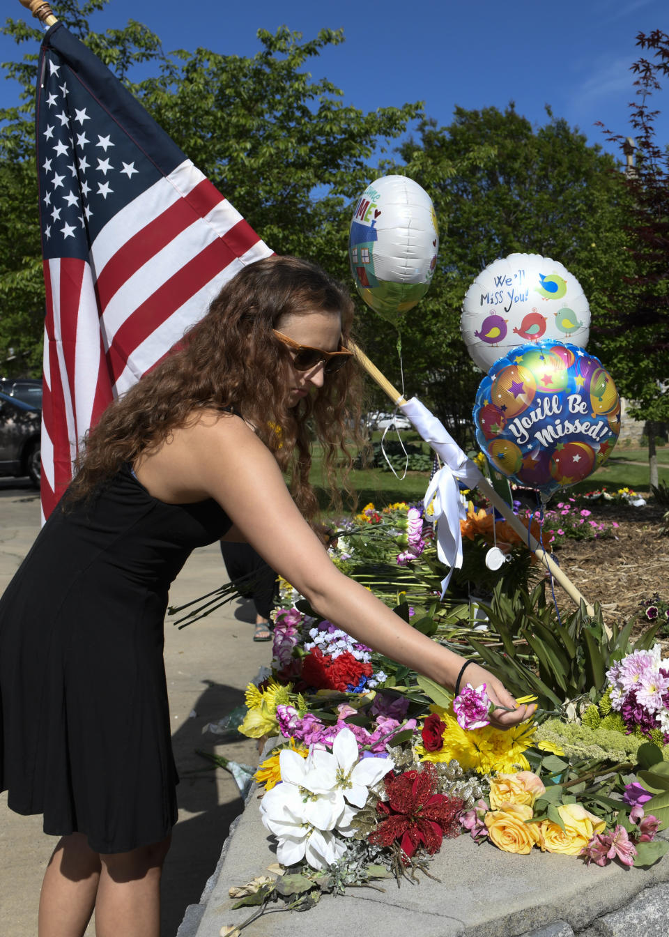 Brittney Jones, a family friend of Riley Howell, places flowers outside the Stuart Auditorium where his memorial service was held in Lake Junaluska, N.C., Sunday, May 5, 2019. Family, hundreds of friends and a military honor guard on Sunday remembered Howell, a North Carolina college student credited with saving classmates by rushing a gunman firing inside their lecture hall. (AP Photo/Kathy Kmonicek)
