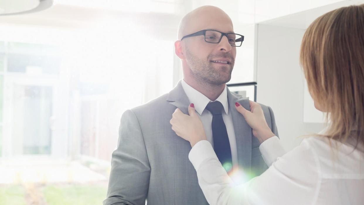 woman fixing a man's suit