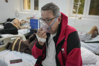 Florin Sandu, 72 years-old, holds an oxygen mask on his face at the COVID-19 unit of the Marius Nasta National Pneumology Institute in Bucharest, Romania, Thursday, Sept. 23, 2021. Daily new coronavirus infections in Romania, a country of 19 million, have grown exponentially over the last month, while vaccine uptake has declined to worrying lows. Government data shows that 91.5% of COVID-19 deaths in Romania between Sept. 18-23 were people who had not been vaccinated. (AP Photo/Vadim Ghirda)