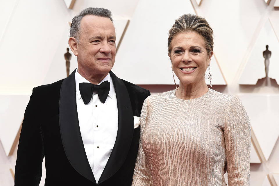 FILE - In this Sunday, Feb. 9, 2020 file photo, Tom Hanks, left, and Rita Wilson arrive at the Oscars at the Dolby Theatre in Los Angeles. On Friday, March 13, 2020, The Associated Press reported on a manipulated image circulating online depicting actor Tom Hanks quarantined at a hospital in Australia with a volleyball that looks like Wilson, his make-believe friend in the movie “Cast Away.” It first circulated as satire. Hanks is in Australia shooting an Elvis Presley biopic directed by Baz Luhrmann. Hanks shared the news about his positive tests on Twitter Wednesday. (Photo by Jordan Strauss/Invision/AP)