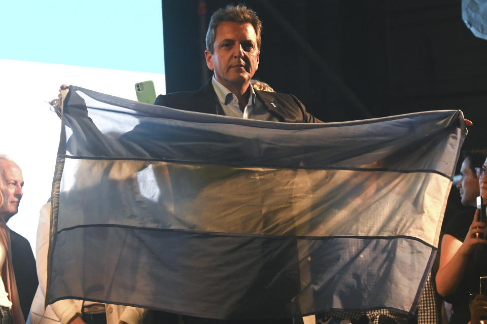 Sergio Massa, Economy Minister and presidential candidate for the ruling party, holds a flag of Argentina outside his campaign headquarters after general elections in Buenos Aires, Argentina, Sunday, Oct. 22, 2023. Massa held the lead in early results and is poised to face off Javier Milei in a second round Nov. 19. (AP Photo/Mario De Fina)