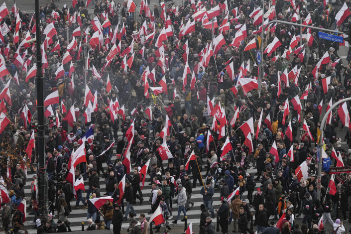 People hold Polish flags during the annual Independence Day march which because of the participation of right-wing groups turned violent in recent years, in Warsaw, Poland, on Thursday, Nov. 11, 2021. The Warsaw mayor and courts banned this year's event due to its history of violence, but the right-wing ruling authorities defied the ban and gave the march state event status to allow it to go ahead. (AP Photo/Czarek Sokolowski)