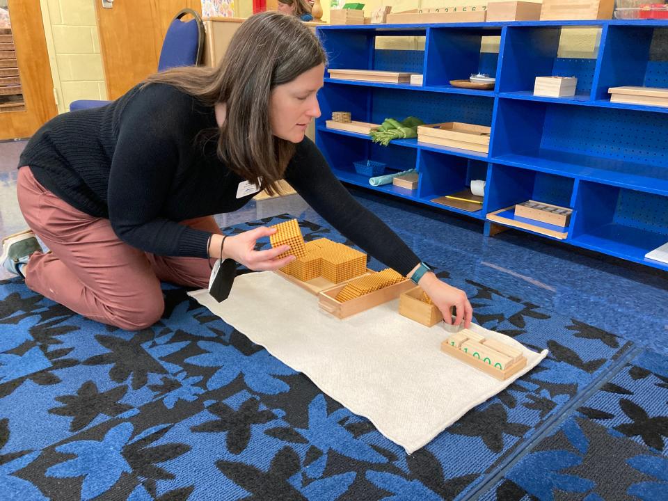 Wren Cook demonstrates several Montessori method learning materials at a Feb. 4, 2023 open house for Mountain City Public Montessori in downtown Asheville.