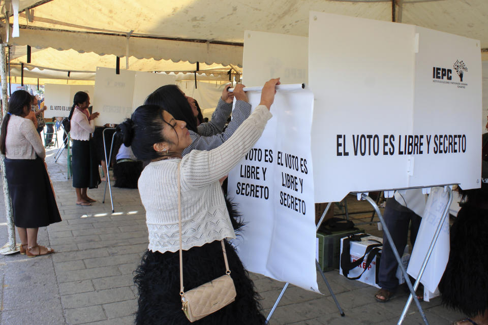 Funcionarios electorales instalan una cabina de votación durante las elecciones generales en San Juan Chamula, México, el domingo 2 de junio de 2024. (AP Foto/Luis Etzin)