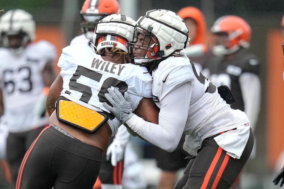 Cleveland Browns' Chuck Wiley (59) and Isaiah McGuire, right, participate in a drill Aug. 7 in Berea.