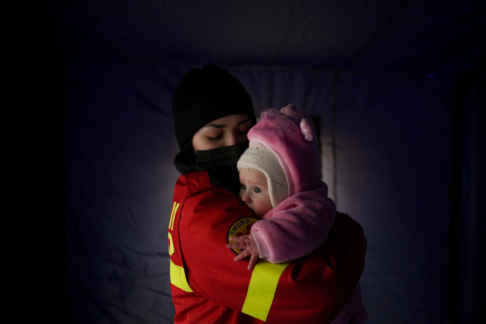 FILE - An employee from the Emergency Situation Inspectorate soothes the crying baby of a family fleeing the conflict from neighbouring Ukraine at the Romanian-Ukrainian border, in Siret, Romania, Feb. 26, 2022. Since Russia launched its attacks against Ukraine on Feb. 24, more than 6 million people have fled war-torn Ukraine, the United Nations refugee agency announced Thursday, May 12, 2022. (AP Photo/Andreea Alexandru, File)