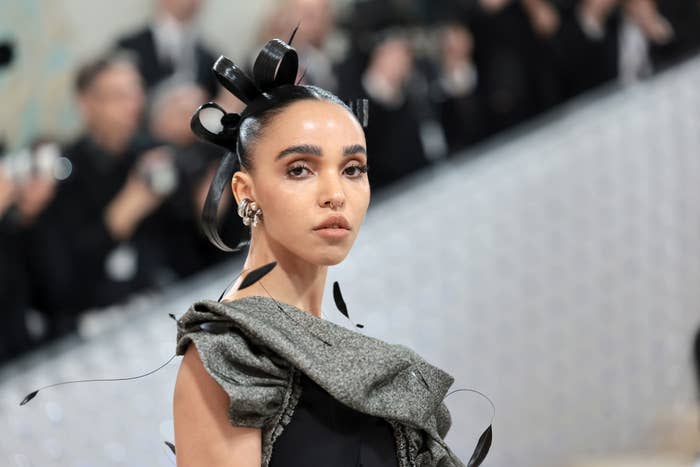 Twigs in a strapless gown with bow headpiece at an event