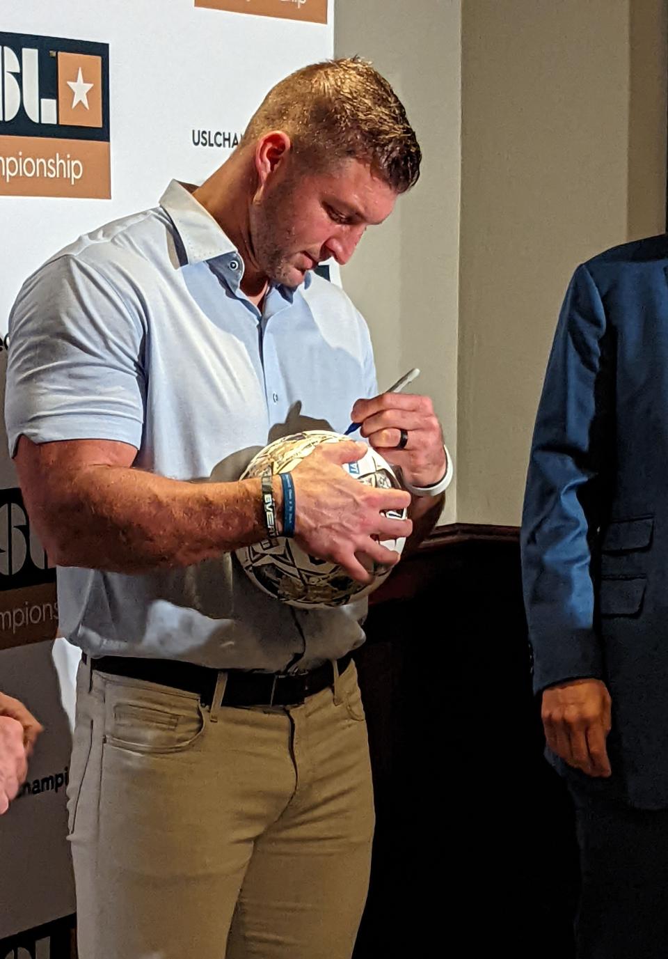 Former Heisman Trophy quarterback Tim Tebow signs a soccer ball after a press conference announcing that Jacksonville's JAXUSL group is receiving a franchise in the United Soccer League Championship on August 30, 2022. [Clayton Freeman/Florida Times-Union]