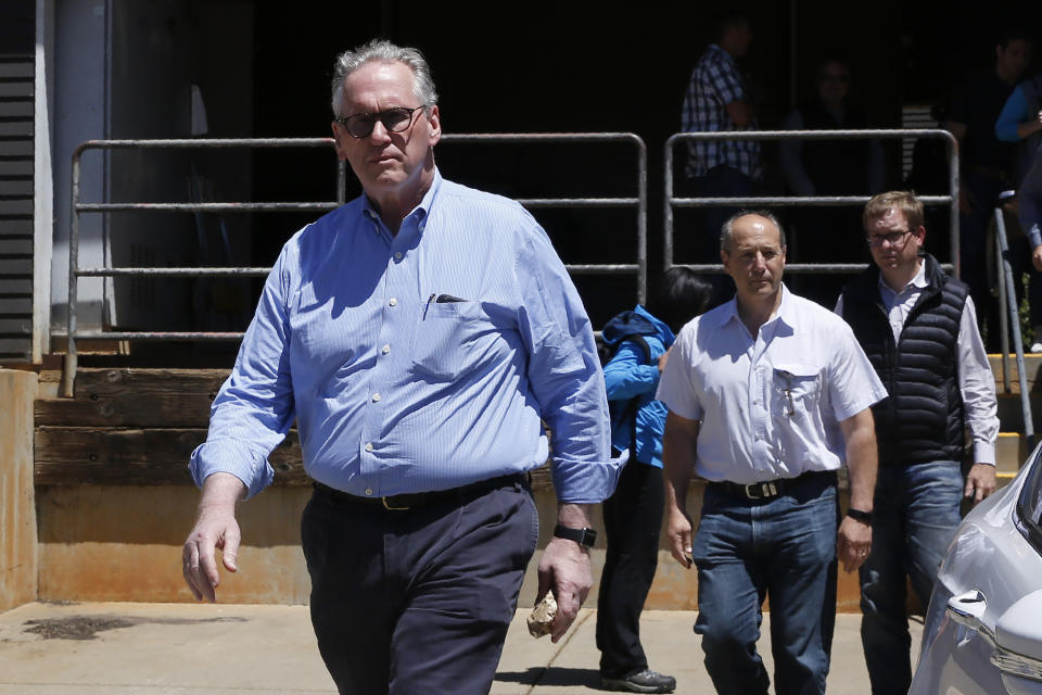 FILE - In this June 7, 2019, file photo, William Johnson, left, the chief executive officer for Pacific Gas & Electric Co., leaves the Paradise Performing Arts Center during a tour of fire ravaged Paradise, Calif. Johnson, the PG&E board and others leaders were ordered by United States District Judge William Alsup to tour the destruction caused last November's Camp Fire. U.S. District Judge William Alsup overseeing Pacific Gas & Electric's criminal probation is holding a hearing Tuesday, May 4, 2021, to consider whether Pacific Gas & Electric violated its criminal probation from a fatal 2010 natural gas explosion by sparking the October 2019 Kincade Fire north of San Francisco. (AP Photo/Rich Pedroncelli, File)