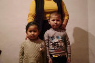 In this Dec. 8, 2018, photo, a 23-year-old Kazakh citizen who asked to be identified by her nickname, Guli, to protect her family from retribution, stands with her children at their home in a village near Almaty, Kazakhstan. The Kazakhstan Foreign Ministry says China is allowing more than 2,000 ethnic Kazakhs to abandon their Chinese citizenship and leave the country, a sign that Beijing may be starting to feel a mounting backlash against a sweeping crackdown on Muslims in its far west region of Xinjiang. Guli says she was stuck in China away from her family for over two years before she was able to return back to Kazakhstan last July. (AP Photo/ Dake Kang)