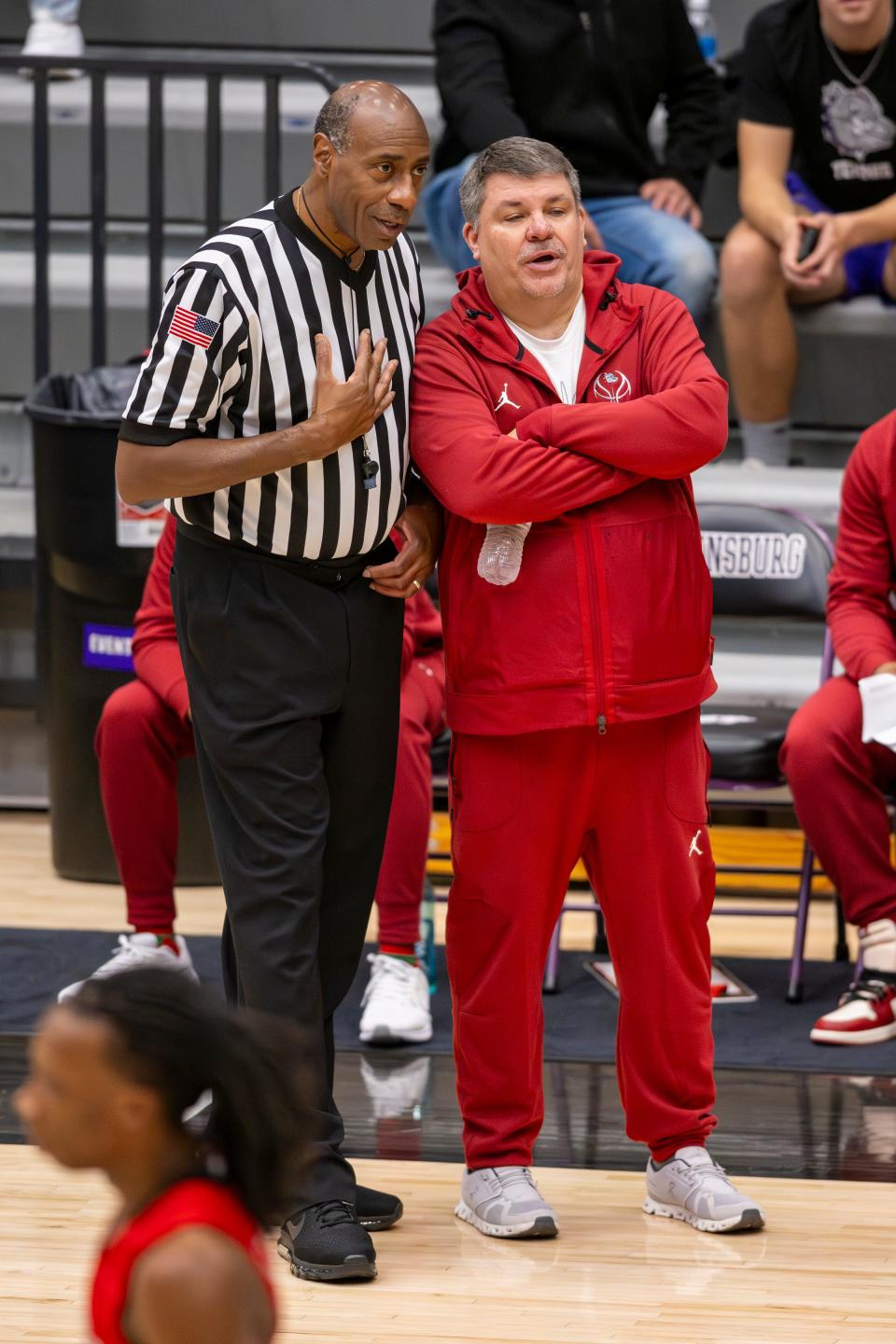 Evansville Bosse High School head coach Shane Burkhart speaks with a game official during the second half of a varsity game against Indianapolis Cathedral High School in the SNKRS4SANTA Shootout, Saturday, Dec. 2, 2023, at Brownsburg High School. Cathedral won, 80-49.