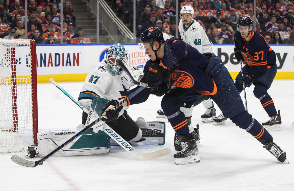 San Jose Sharks goalie James Reimer (47) makes a save against Edmonton Oilers' Jesse Puljujarvi (13) during second-period NHL hockey game action in Edmonton, Alberts, Thursday, April 28, 2022. (Jason Franson/The Canadian Press via AP)