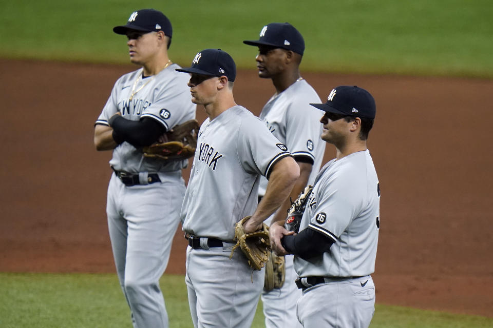 Jugadores de los Yanquis de Nueva York esperan a que el pitcher Michael King caliente durante la quinta entrada del juego de las Grandes Ligas contra los Rays de Tampa Bay, el jueves 13 de mayo de 2021, en St. Petersburg, Florida. (AP Foto/Chris O'Meara)