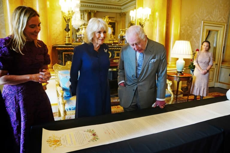Le roi Charles III et la reine Camilla se voient remettre le Coronation Roll, le registre officiel de leur couronnement, au palais de Buckingham, le 1er mai 2024 à Londres (Victoria Jones)