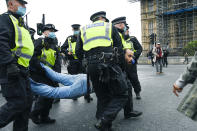 Police detain a man, during a coronavirus anti-lockdown protest on Westminster Bridge, in London, Saturday, Oct. 24, 2020. (AP Photo/Alberto Pezzali)