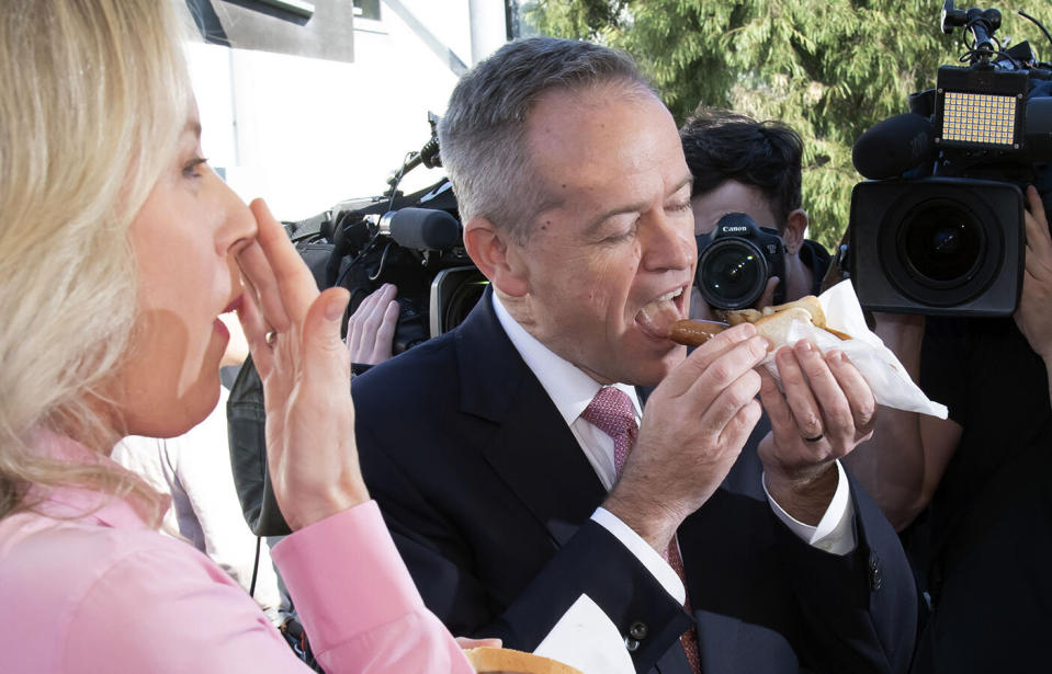 Bill Shorten and wife Chloe eat a 'democracy sausage' in the opposition leader's Victorian seat of Maribyrnong. Source: AP Photo/Andy Brownbill