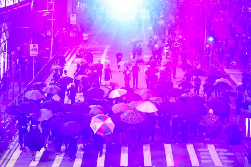 FILE PHOTO: Anti-government protesters protect themselves with umbrellas as they move toward riot police officers during a protest in Sham Shui Po district