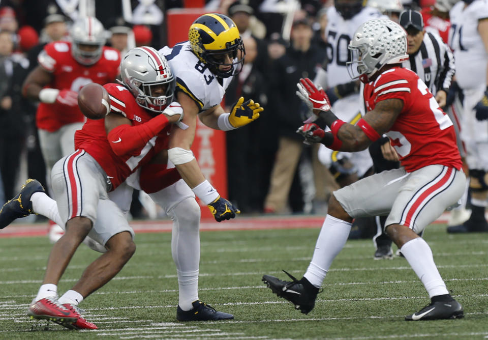 Ohio State defensive backs Jeffrey Okudah, left, and Brendon White, right, break up a pass intended for Michigan tight end Zach Gentry during the second half of an NCAA college football game Saturday, Nov. 24, 2018, in Columbus, Ohio. Ohio State beat Michigan 62-39. (AP Photo/Jay LaPrete)