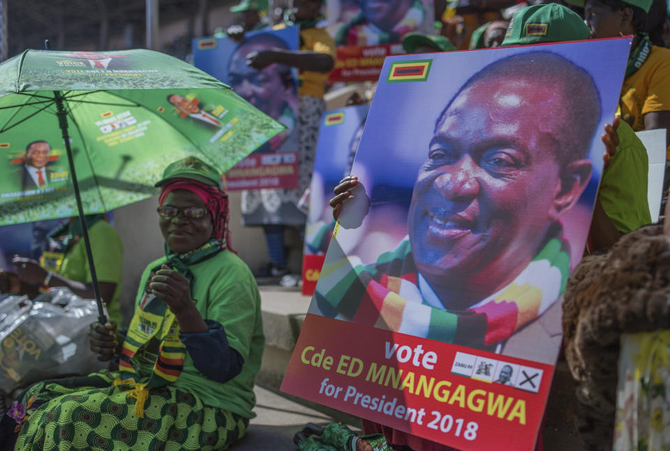 Ruling ZANU PF supporters attend an election rally in Harare, Zimbabwe on Saturday July 28, 2018. Zimbabwean President Emmerson Mnangagwa, shown on poster, and main challenger Nelson Chamisa are set to hold final campaign rallies ahead of Monday's election in a country seeking to move past decades of economic and political paralysis. (AP Photo)