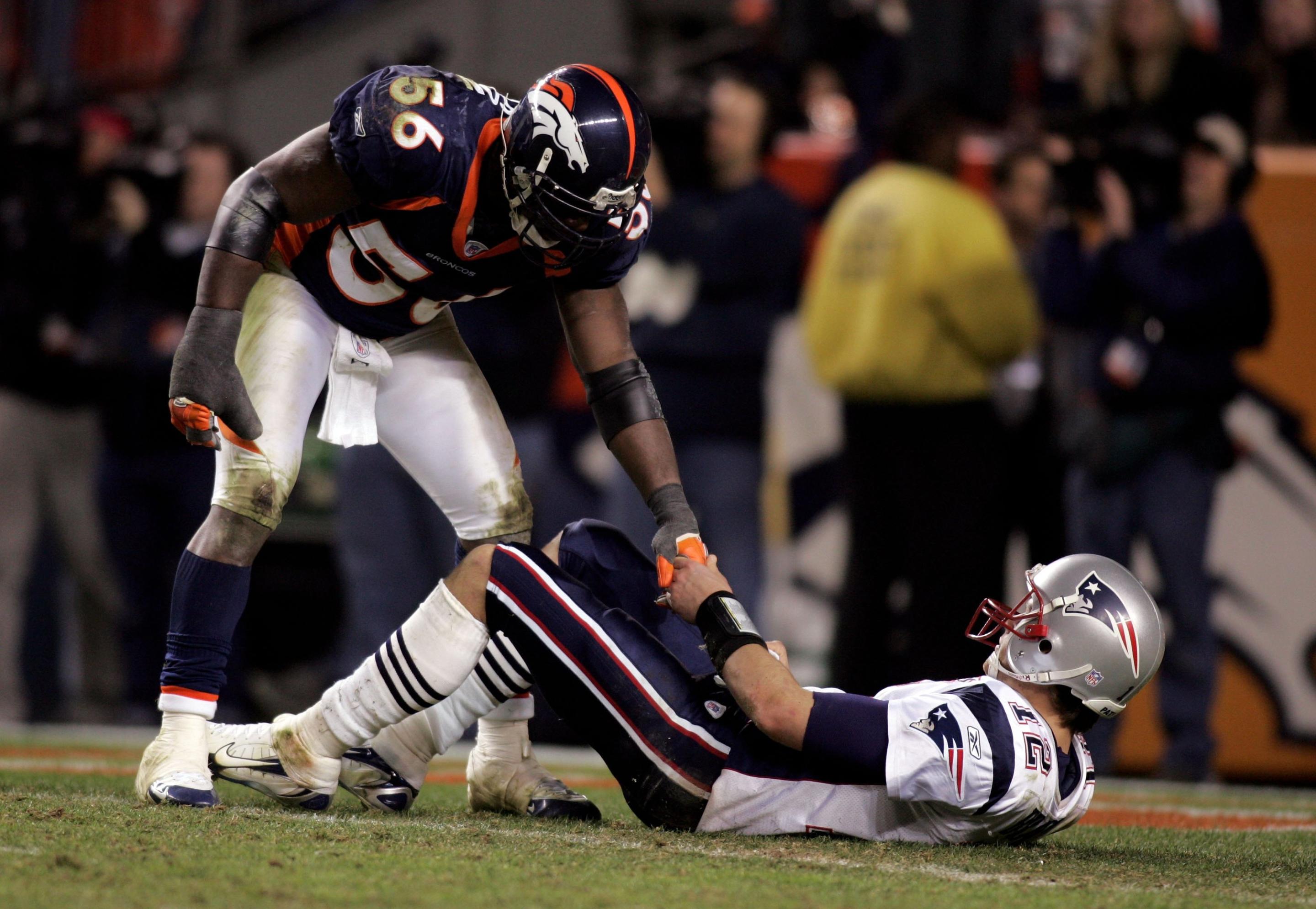 DENVER - JANUARY 14:  Linebacker Al Wilson #56 of the Denver Broncos helps quarterback Tom Brady #12 of the New England Patriots up as Brady lays on his back during the fourth quarter of the AFC Divisional Playoff game on January 14, 2006 at Invesco Field at Mile High in Denver, Colorado. The Broncos defeated the Patriots 27-13 to advance to the AFC Championship game. (Photo by Ronald Martinez/Getty Images)