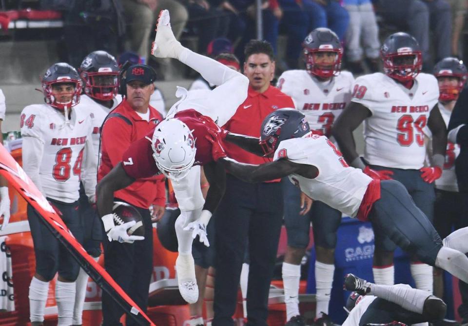 Fresno State running back Jordan Mims, left, is pushed out of bounds by New Mexico’s Jerrick Reed II in the Bulldogs’ 34-7 victory over the Lobos Saturday, Nov. 13, 2021 in Fresno.