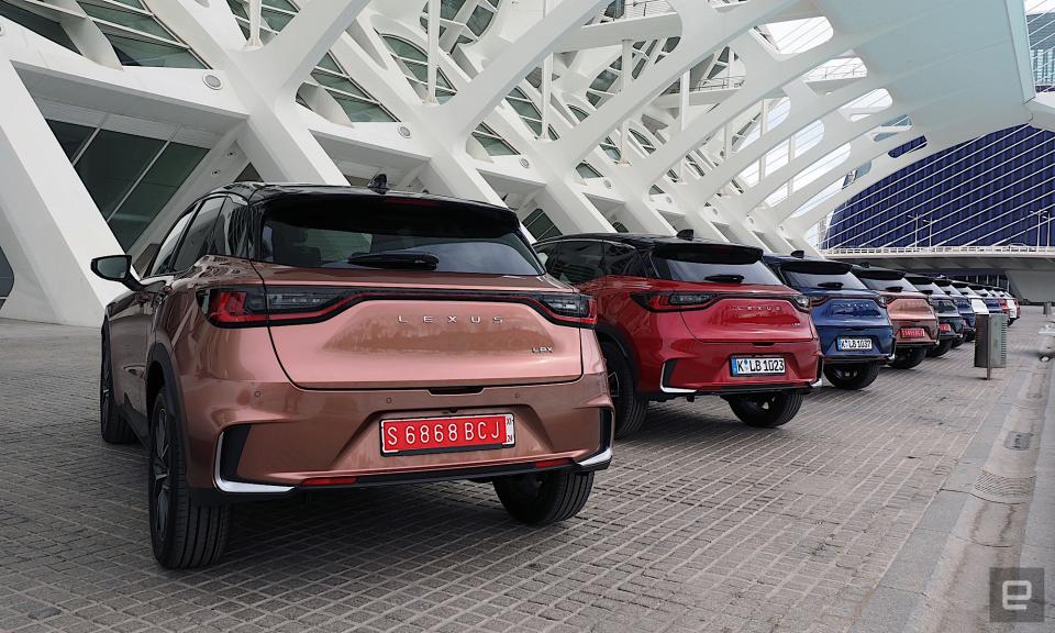 Image of a Lexus LBX parked under the canopy of the City of Arts and Sciences in Valencia. The car is painted in “Sonic Copper,” a sort of metallic orange.