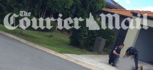 The video shows the man being held down by police in the driveway of a home. Photo: Courier Mail