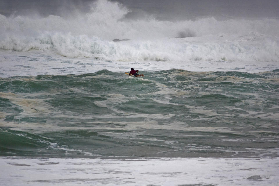 FILE - Ramon Navarro, of Chile, paddles out to ride in the Eddie Aikau big-wave surfing contest in Waimea Bay near Haliewa, Hawaii on Feb. 25, 2016. One of the world's most prestigious and storied surfing contests is expected to be held Sunday, Jan. 22, 2023, in Hawaii for the first time in seven years. And this year female surfers will be competing alongside the men for the first time in the 39-year history of The Eddie Aikau Big Wave Invitational. (AP Photo/Caleb Jones, File)