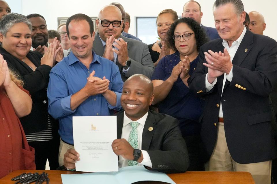 Milwaukee Mayor Cavalier Johnson, center, get a round of applauses from local political leaders after signing the Sales Tax Ordinance that approves the new 2% sales tax which will be collected to fund City of Milwaukee services and obligations, Friday, July 14, 2023 at the Mitchell Street Library at 906 W. Historic Mitchell St., in Milwaukee.