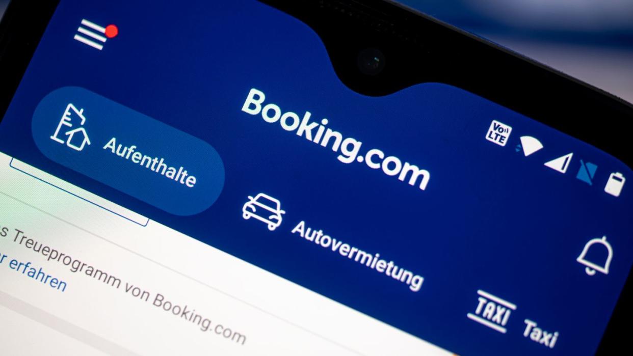 Auf einem Smartphone ist die App des Reiseportals Booking.com zu sehen.